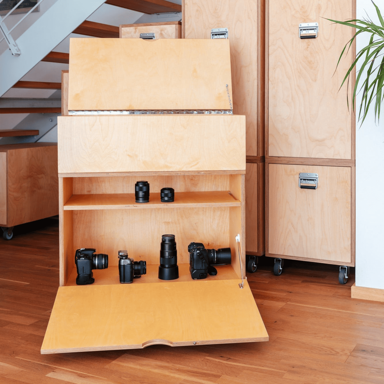 Moderner Einbauschrank unter der Treppe als maßgefertigter schrank mit viel stauraum aus hellem Holz. Dank integrierter Rollen ist der Schrank nach Maß bewegbar und bietet flexiblen Stauraum.