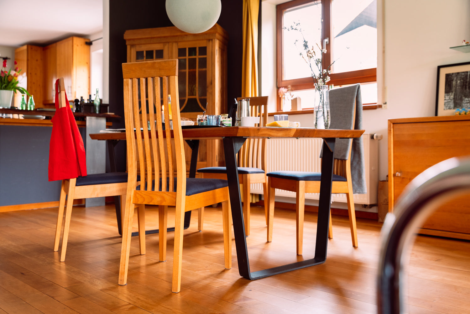 Holztisch in Freiburg: Ein stilvoller, minimalistischer Esstisch aus massivem Holz. Die glatte, nach Maß gefertigte Tischplatte dominiert den hellen Raum und schafft ein modernes, aber warmes Ambiente.