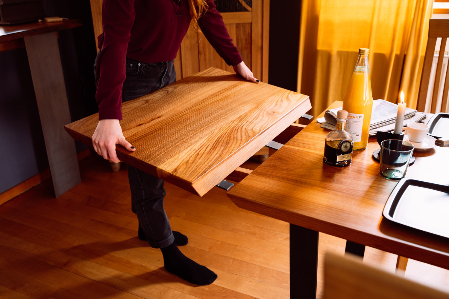 Hochwertiger Massivholztisch mit einzigartiger Maserung. Die Detailaufnahme zeigt die perfekte Verarbeitung der Tischverlängerung, die zur warmen und gemütlichen Atmosphäre beiträgt.