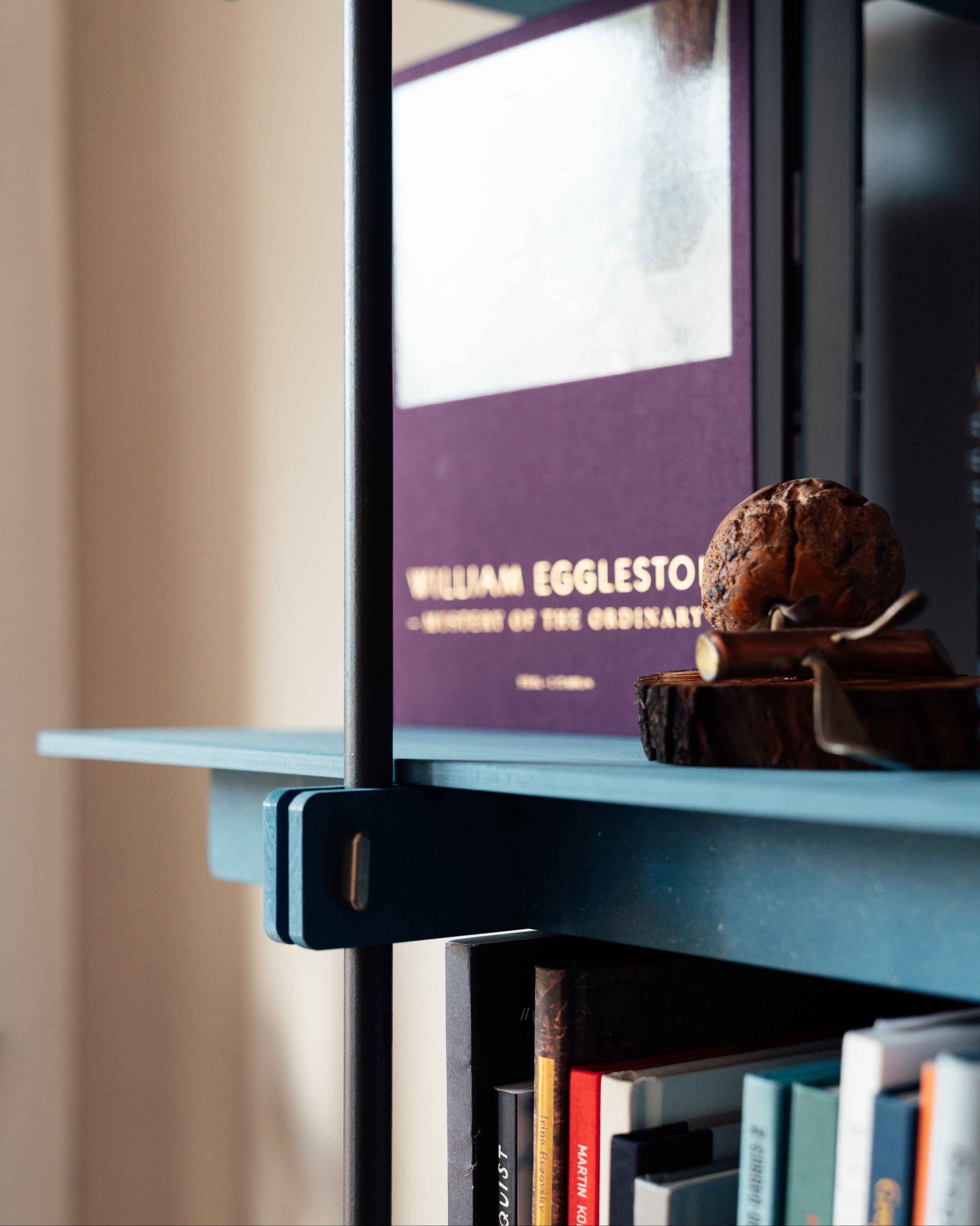 Design Regal aus blauem Stahl mit Holzablagen, offenes Regal mit minimalistischem Stahltürrahmen.