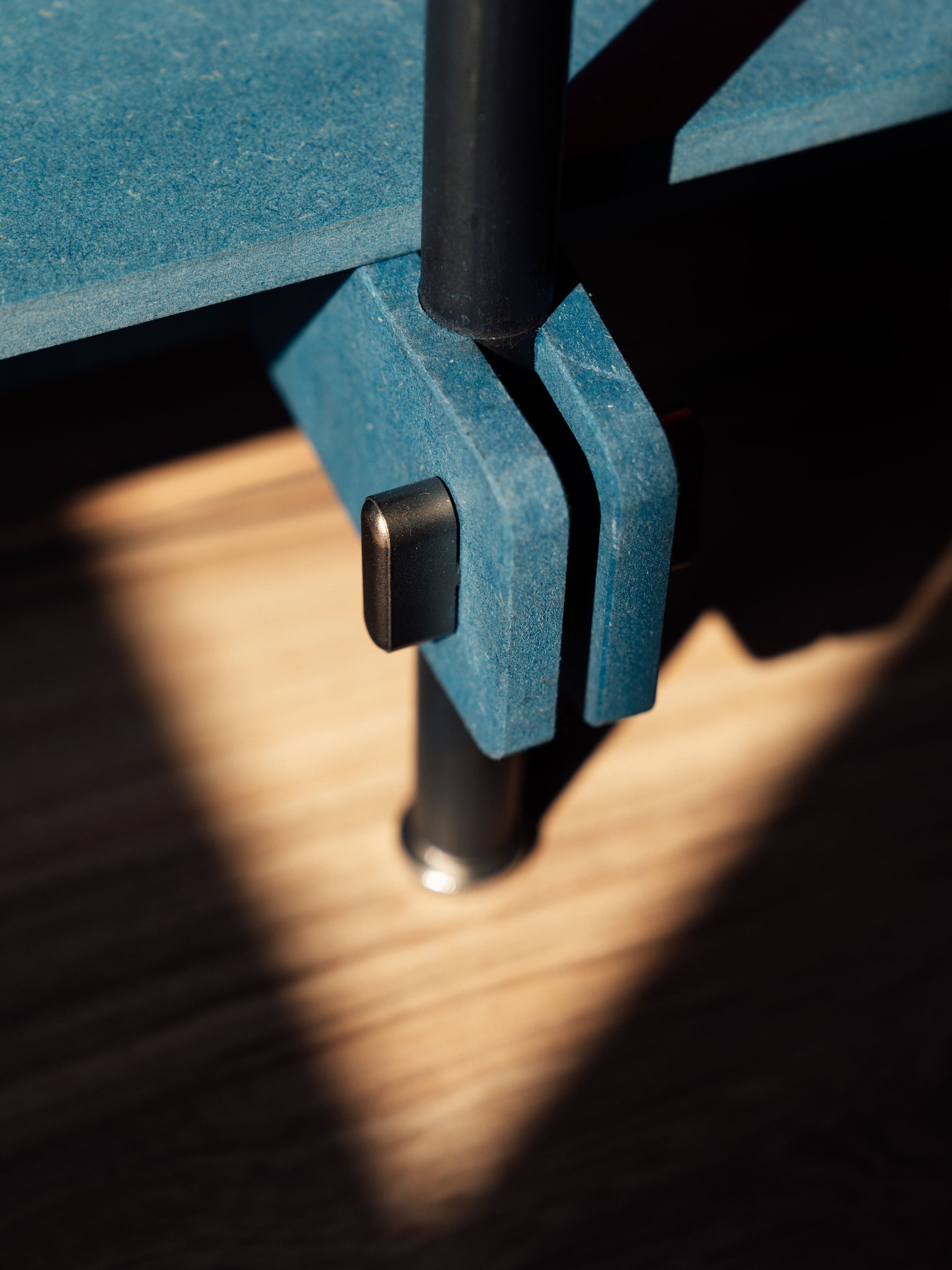 Blaues regalsystem holz mit anthrazitfarbenem stahlrahmen und schwarzem verbindungselement, design regal detail.