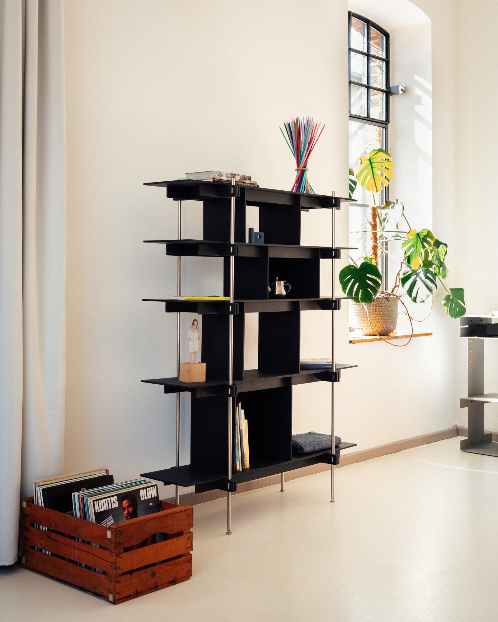 Schwarzes offenes Design Regal aus Stahl mit Holzablagen, moderne stabile Konstruktion, Regal mit asymmetrischem Rahmen.