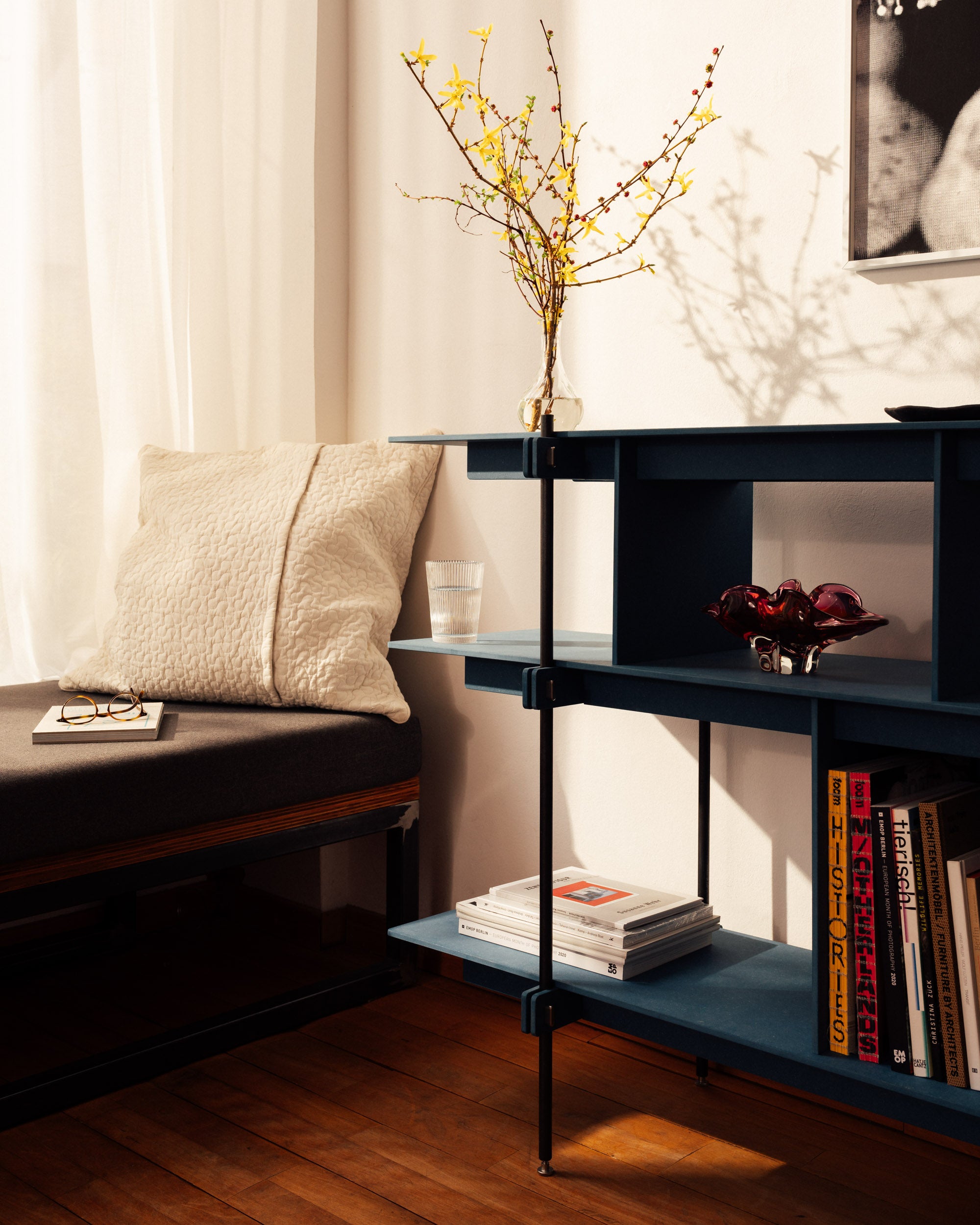 Blau lackiertes offenes Holzregal mit Stahlrahmen, zwei Ablagen, minimalistisch und modern.