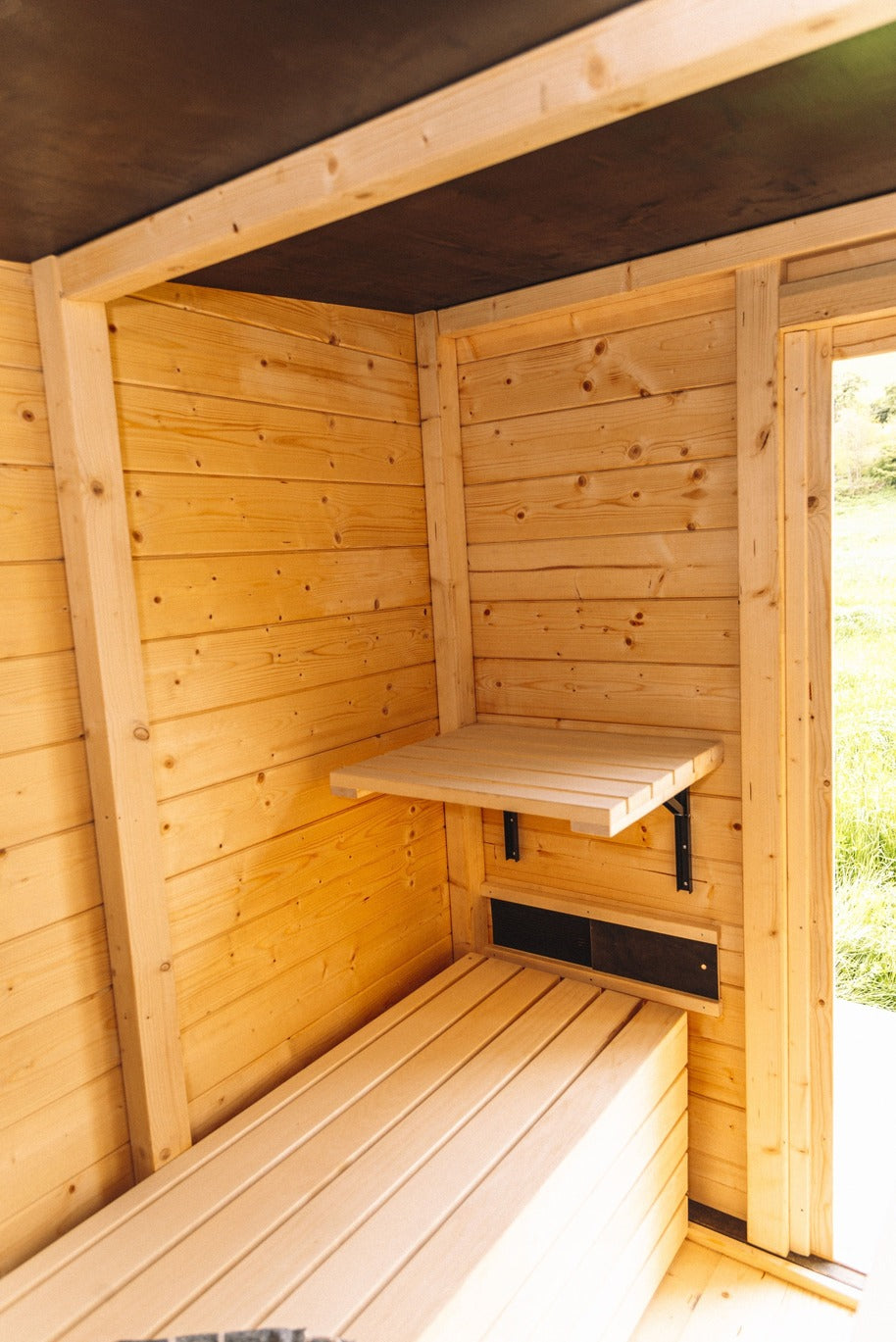 Mobile Sauna aus hellem Holz mit klappbarem Tisch und Sitzbank, mobile Sauna Freiburg und Schwarzwaldideen.