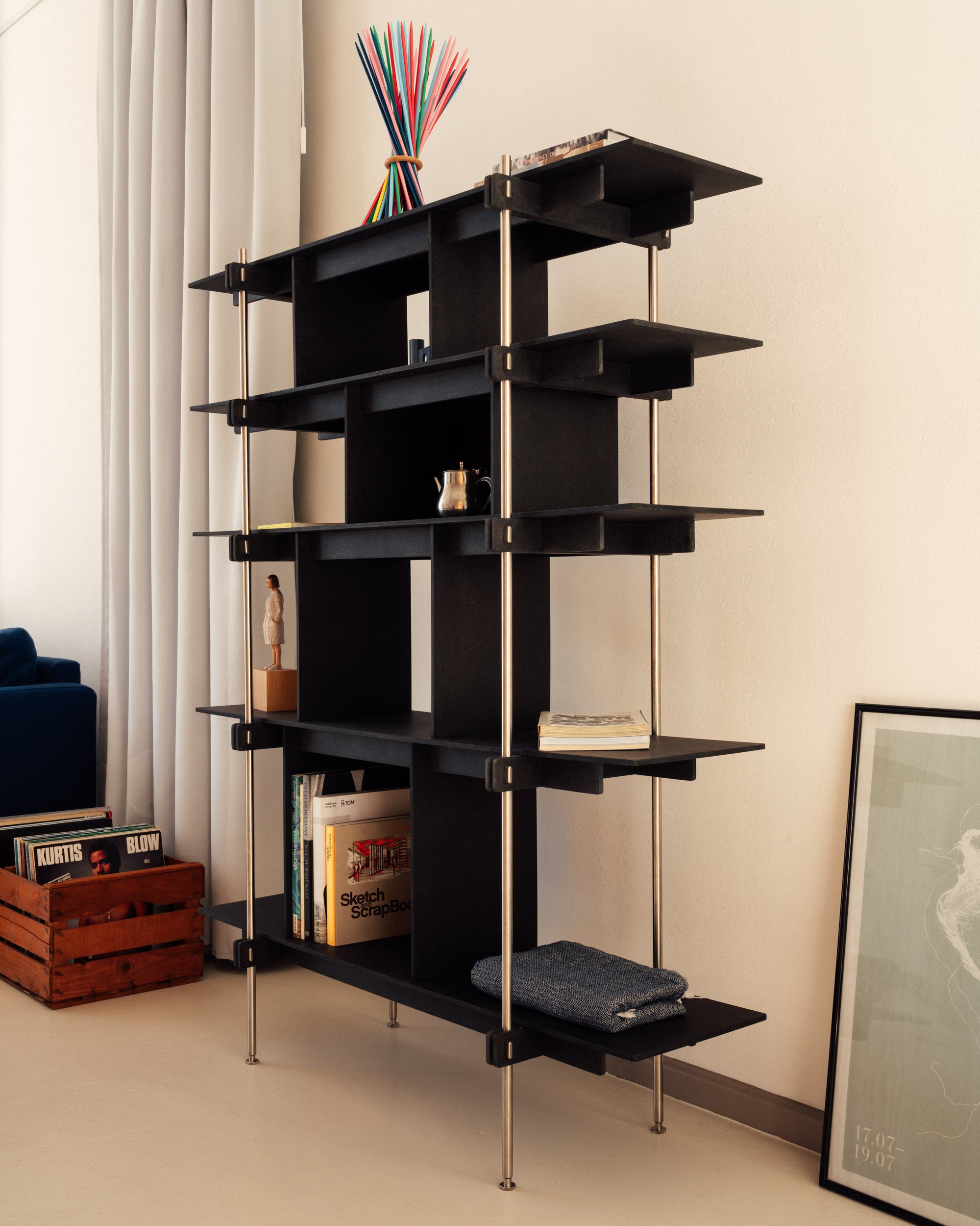 Schwarzes Design Regal mit offenem Regalsystem aus Stahl und mehreren Ablageflächen und Türen.