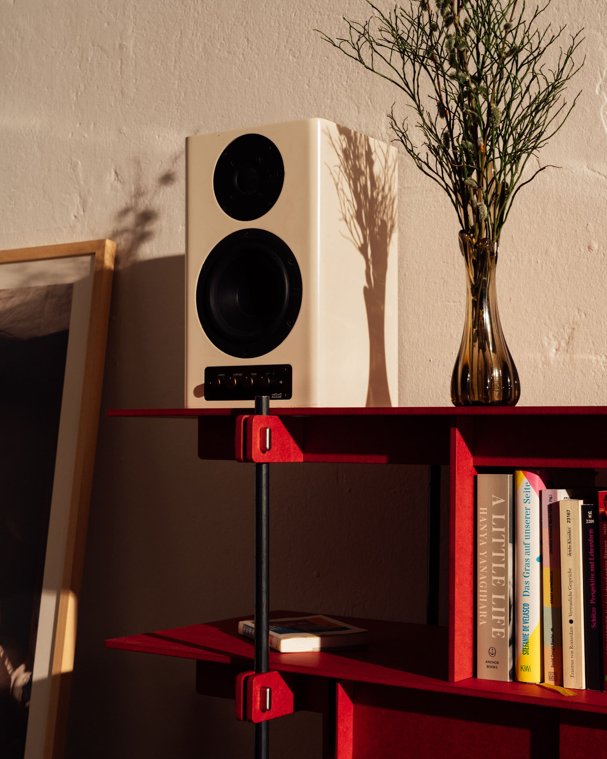 Rotes Design Regal aus Stahl mit offenen Regalfächern und Holzböden.