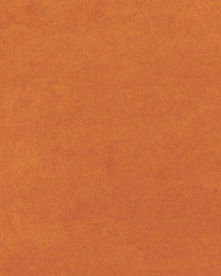 Das Foto zeigt ein Detail einer orangefarbenen MDF-Platte. Das Material ist durch und durch gefärbt und die natürliche Haptik der Oberfläche, die auch einige Holzfasern erkennen lässt, wird durch eine ökologische Ölung hervorgehoben.