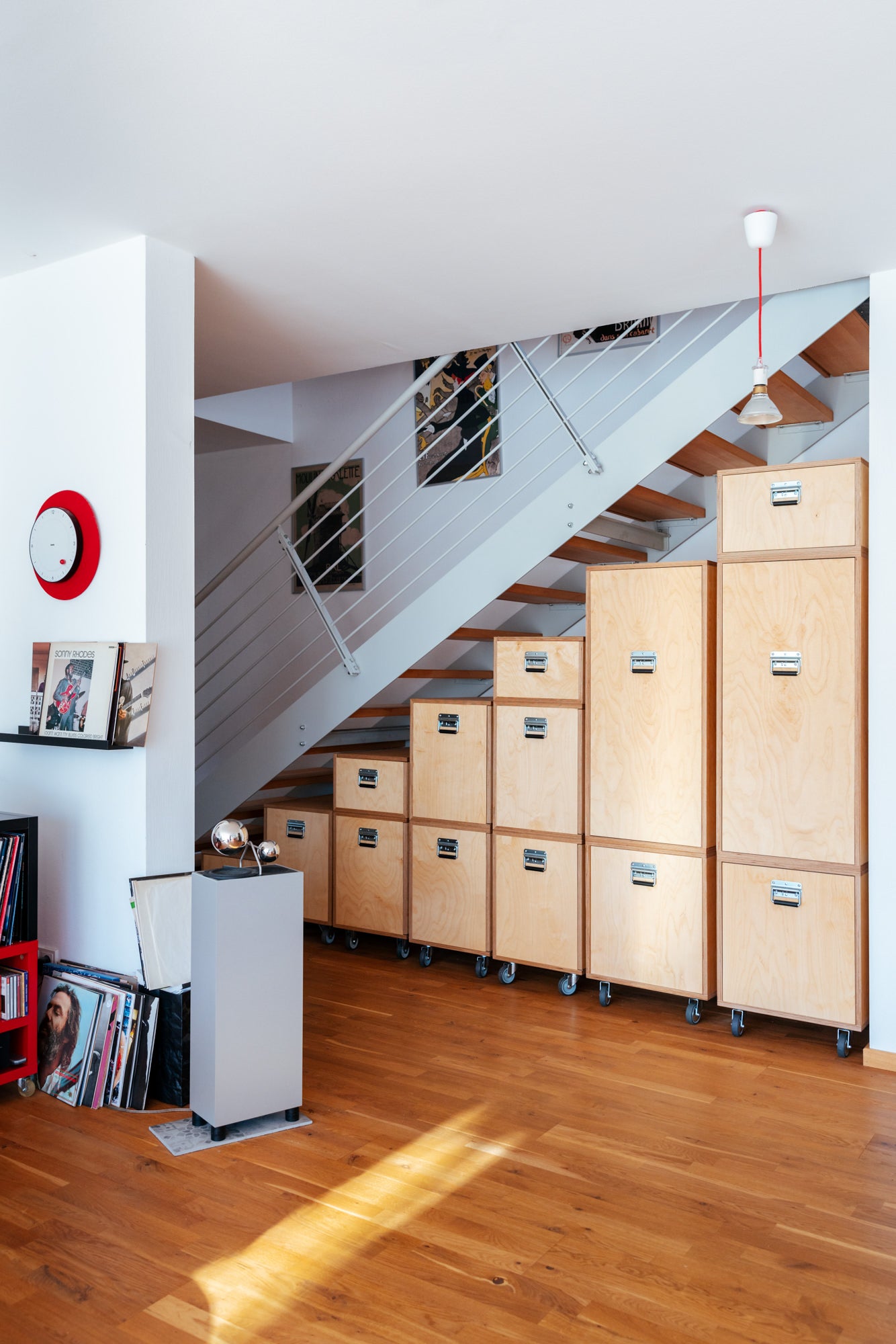 Einbauschrank unter der Treppe aus hellem Holz mit Schubladen und Türen, maßgefertigter Bücherschrank und Schrank nach Maß.
