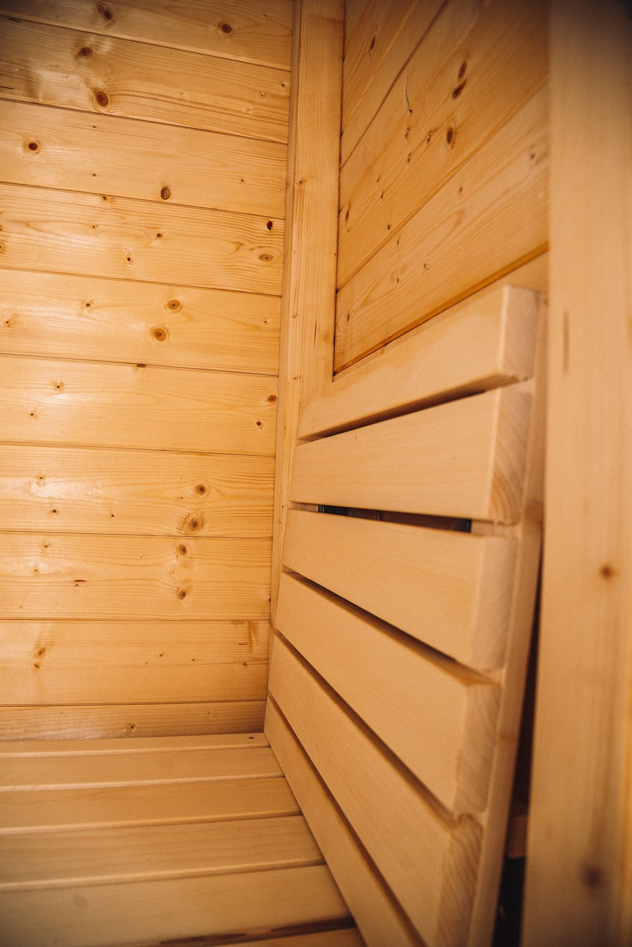 Mobile Sauna innen mit hellen Holzwänden und horizontalen Rückenlehnen aus Holz, ideal für Sauna kaufen und mobile Sauna.