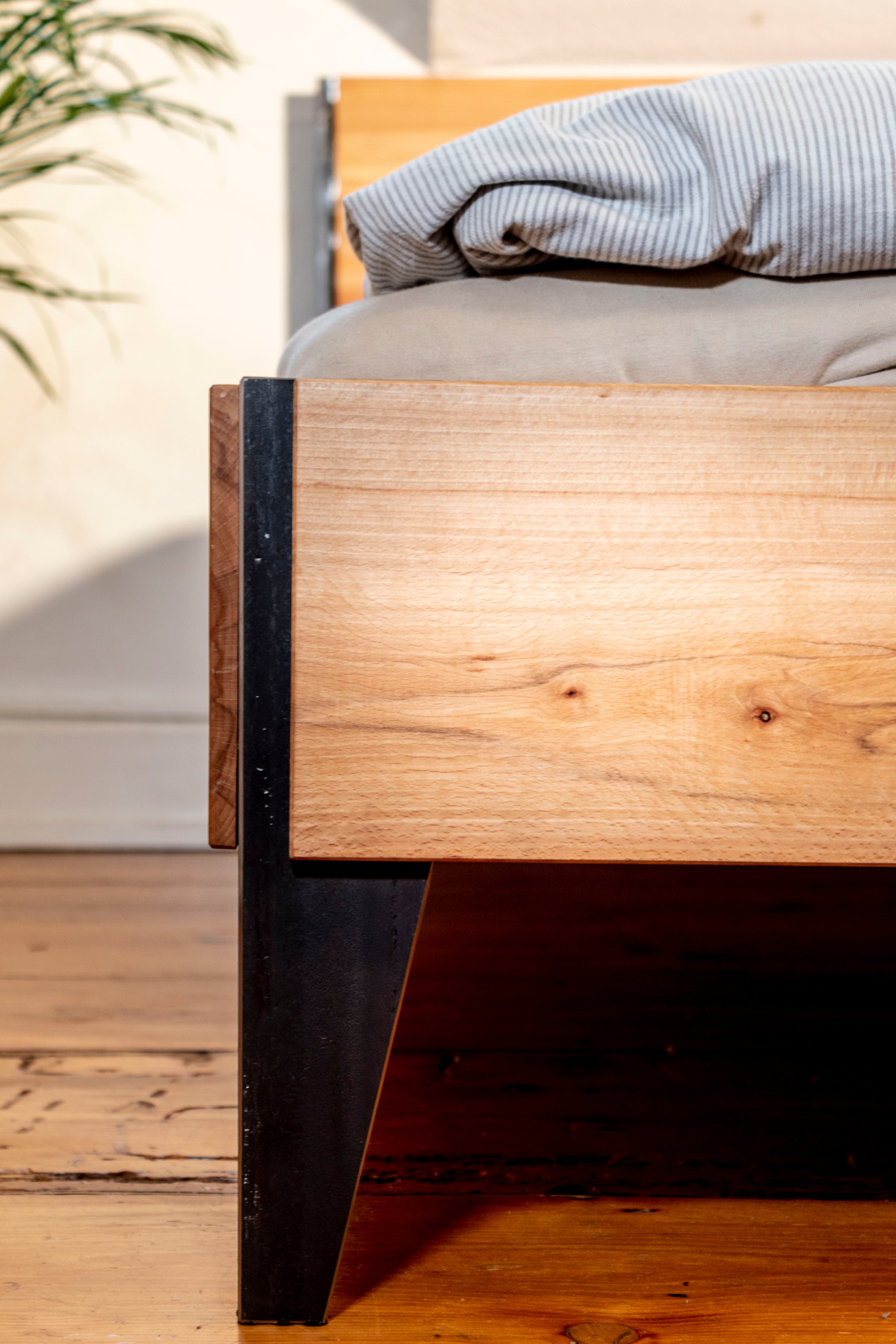 Holzbettrahmen mit schwarzem Stahlgestell im modernen Regalsystem Design.