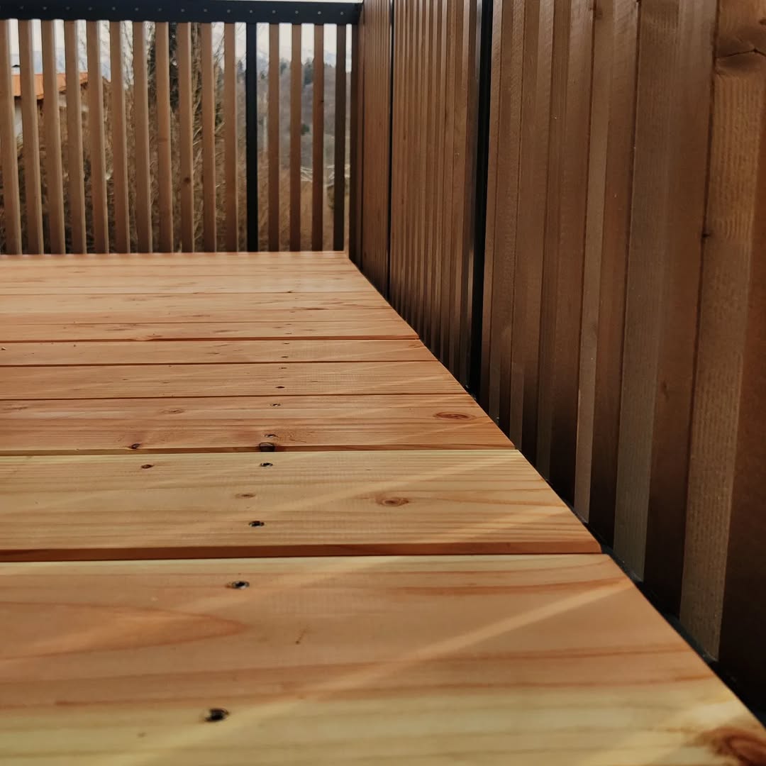 Terrasse aus Holz mit Holzgeländer und Metallbalkon als stilvolle Terrasse Ideen.